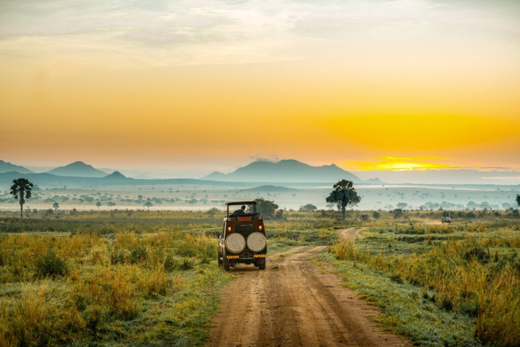 Safari vehicle overlooking vast savannah plains in Kidepo Valley National Park, Uganda