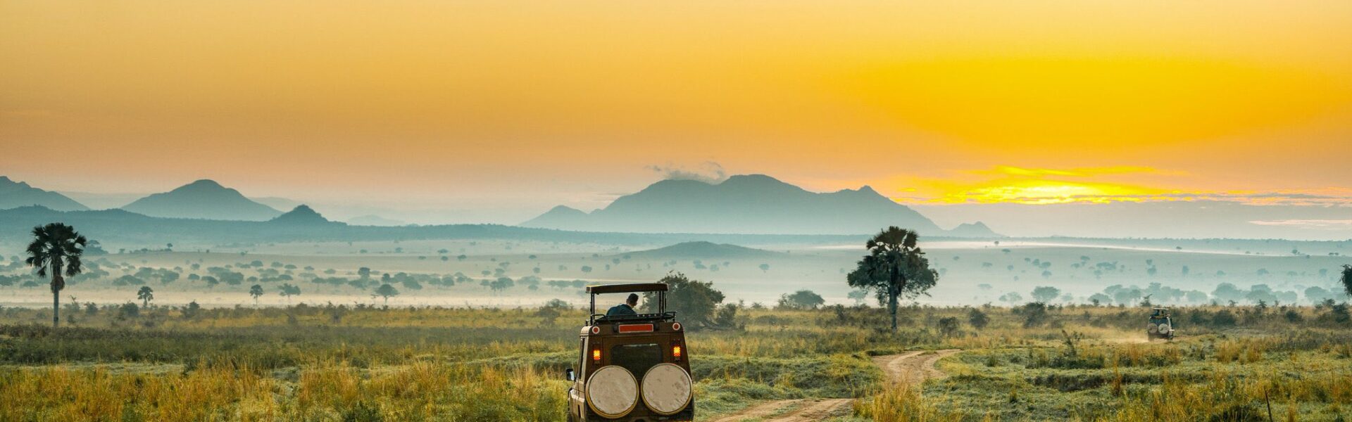 Safari vehicle overlooking vast savannah plains in Kidepo Valley National Park, Uganda