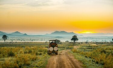 Safari vehicle overlooking vast savannah plains in Kidepo Valley National Park, Uganda